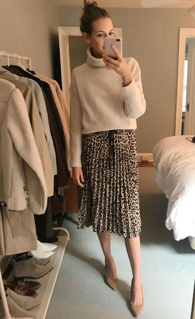 With beige loose cropped turtleneck sweater and beige pumps