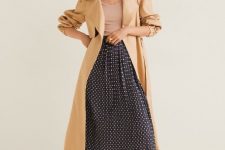 With beige top, beige midi trench coat and black leather flat sandals