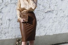 With brown leather high-waisted knee-length skirt, leopard printed clutch, earrings and golden pumps