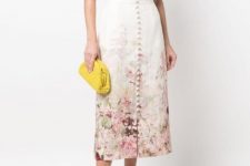 With floral printed ruffled blouse, yellow clutch and beige leather low heeled shoes