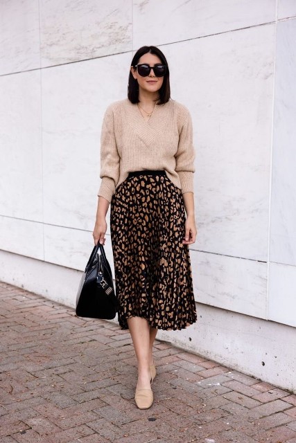 With sunglasses, beige loose sweater, beige flat shoes and black leather bag