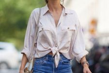 With sunglasses, denim distressed shorts and beige leather bag