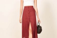 With white sleeveless crop top, black basket bag and beige heeled shoes