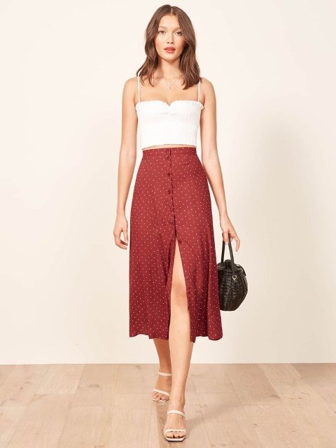 With white sleeveless crop top, black basket bag and beige heeled shoes