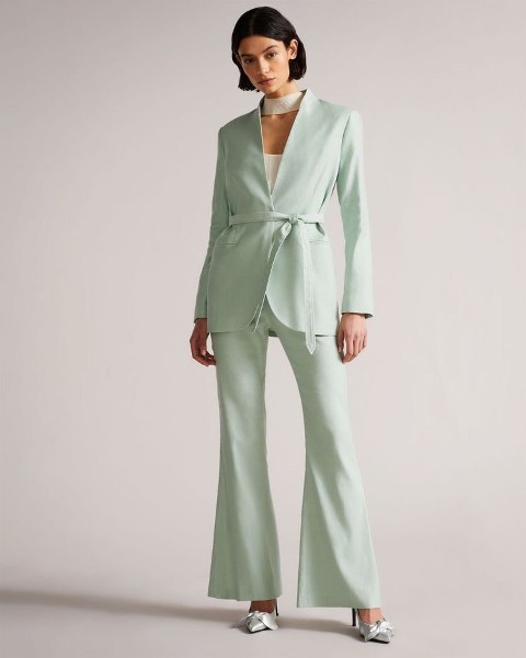 With white top, mint green linen flare pants and silver embellished high heels