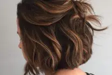 a black bob done with caramel balayage, with a lot of volume, waves is a lovely idea to rock