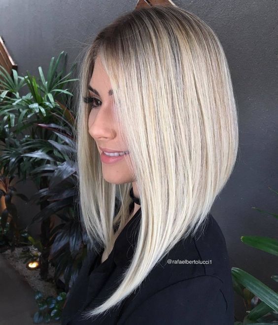 a blonde angled long bob with side parting and strict lines is a catchy and chic idea that stands out