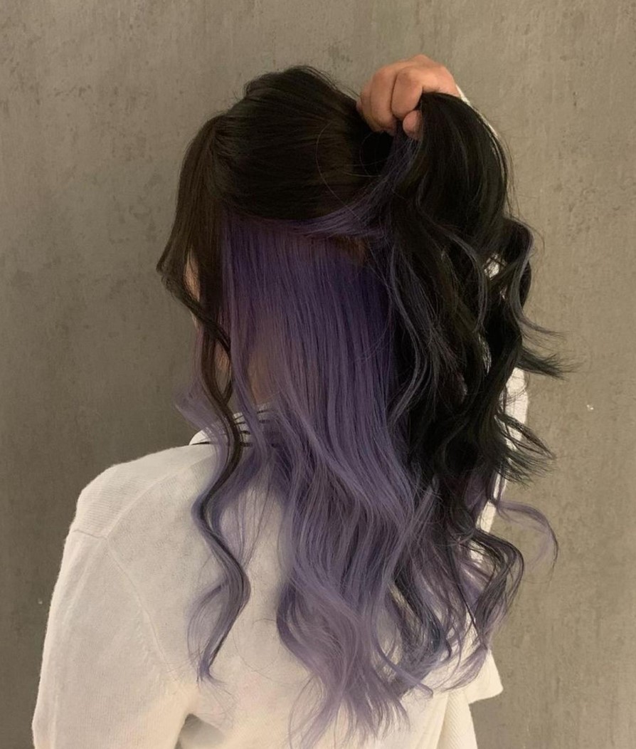 A bold peekaboo hairstyle with black and lilac locks and waves is a fun and lovely idea for making a statement
