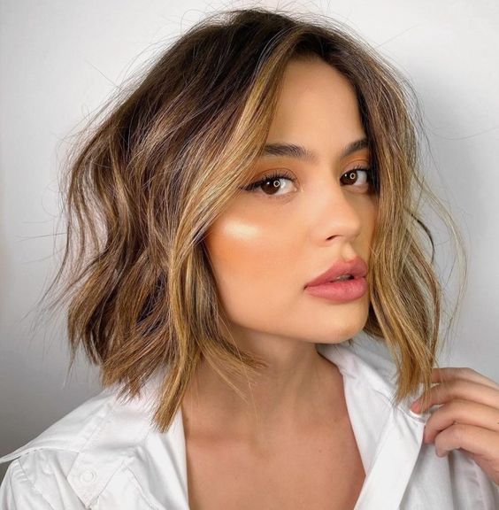 a brown bob with caramel balayage and a money piece, with volume and messy waves is amazing