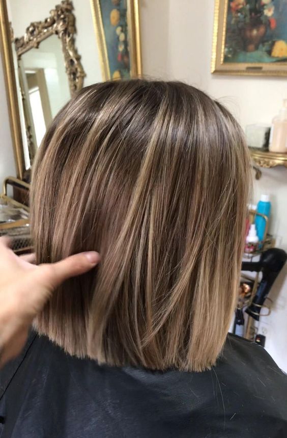 a light brown bob with blonde balayage that gives straight hair a lot of visual volume and interest