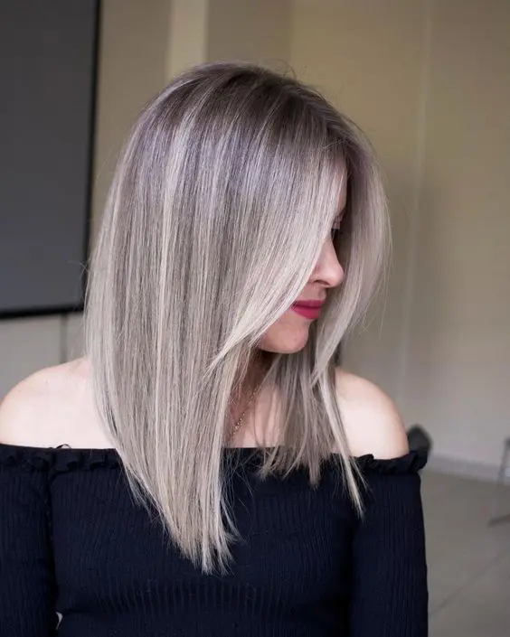 a long blonde angled bob with curtain bangs and blonde balayage is a cool and girlish idea to try