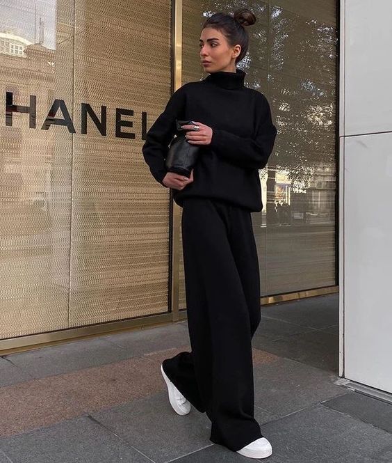 a minimalist total black look with a turtleneck sweater, black trousers, white sneakers and a black bag for the fall