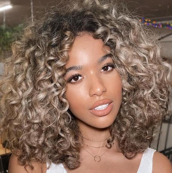 beige beach blonde hair with chunky highlights, with a few inches of root shadow are throwing us back to sun-scorched beach days