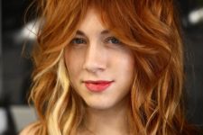 bold copper red hair with peekaboo blonde locks, a chopped haircut and waves is a messy and catchy idea