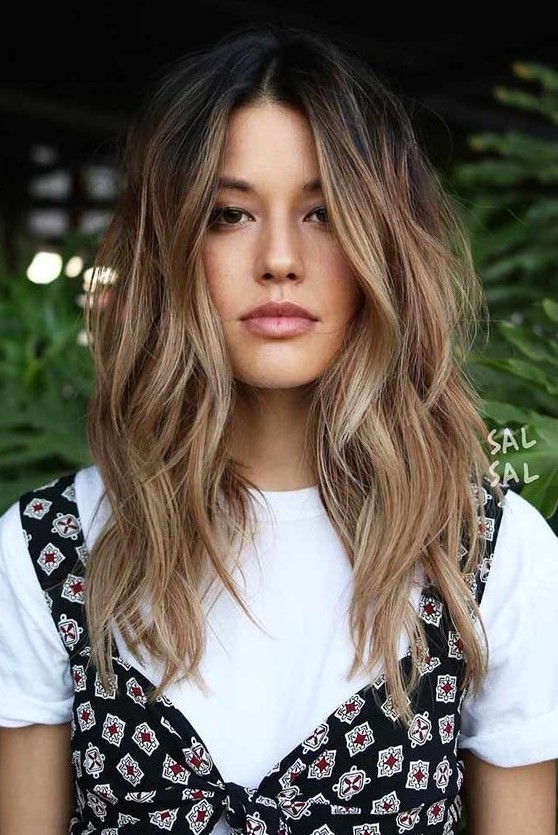 dark brunette hair with beautiful and messy waves and sunkissed balayage is a chic and pretty idea that looks rather natural