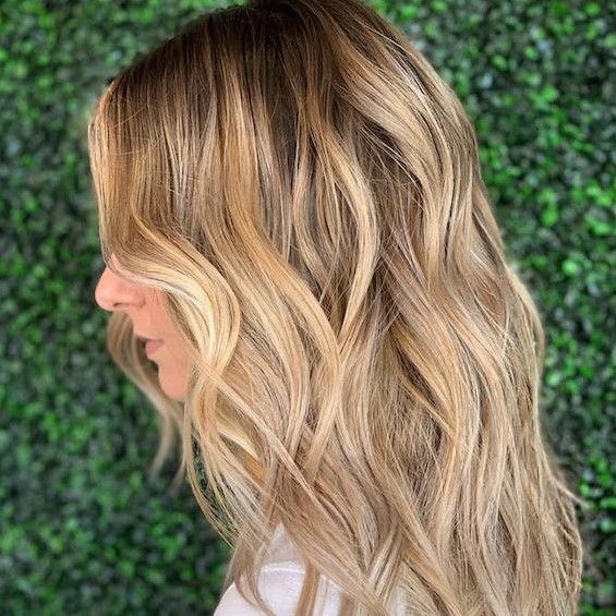 honey beach blonde hair with balayage babylights and slight and delicate waves looks very sweet and very chic