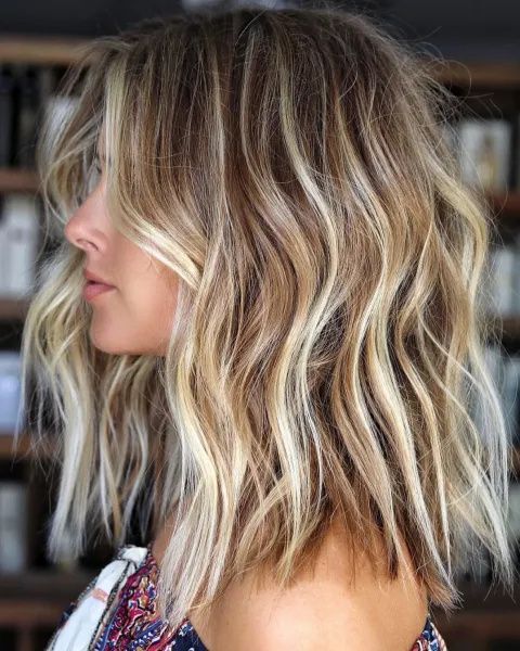 light brown hair of medium length with icy and beachy blonde balayage and babylights plus a texture for a beachy look