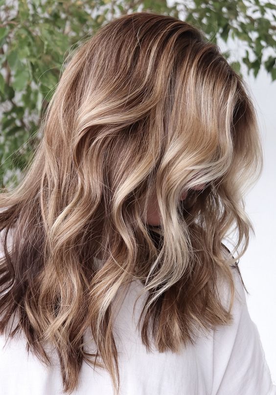 light brunette hair with blonde balayage and waves looks relaxed, chic and beach-inspired