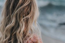 long and wavy beahc blonde hair with beach waves but a darker root is a stylish idea to give a beach touch to the look