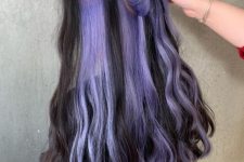 long black wavy hair with peekaboo purple locks is a catchy and super bold idea with plenty of color
