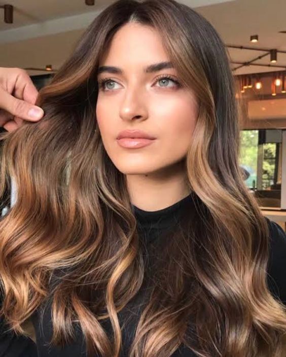 long brunette hair accented with caramel and bronde highlights looks soft, chic and sunkissed just a little bit