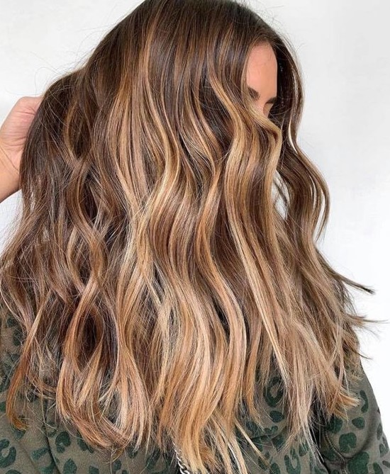 long wavy brunette hair with sunkissed balayage is a pretty idea for summer that doesn't require much maintenance