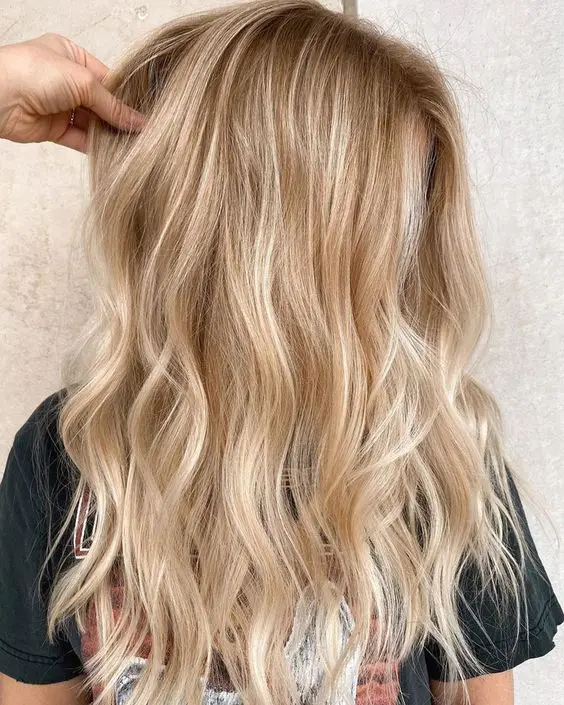 lovely blonde hair with a darker root, with gold and icy blonde balayage and waves loosk truly beach-like and cool
