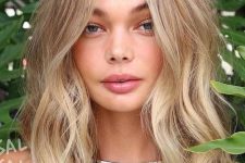medium length blonde hair with beach balayage and messy waves is a cool idea for a summer feel