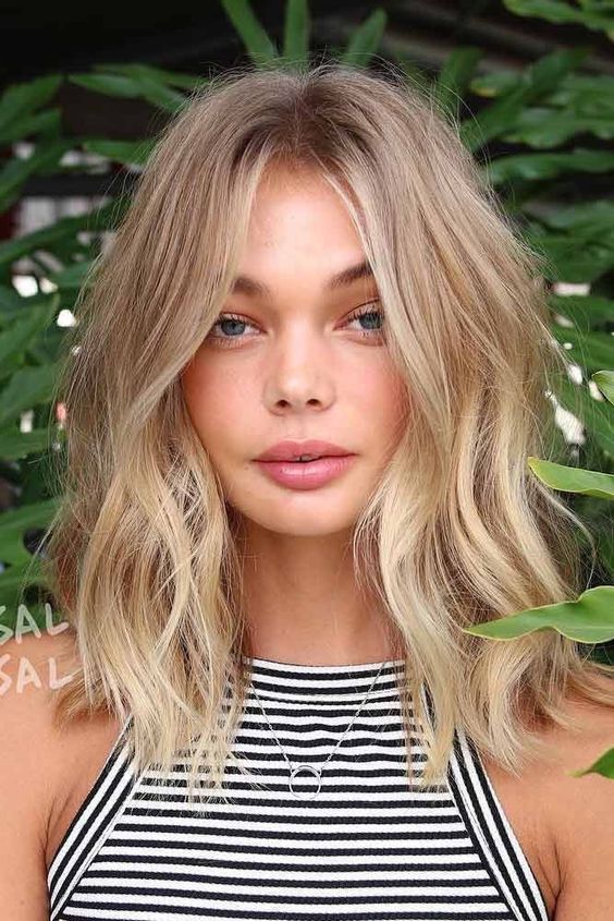 medium length blonde hair with beach balayage and messy waves is a cool idea for a summer feel