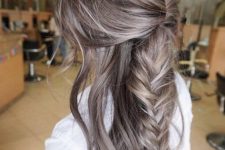 super long mousy brown hair with a large messy fishtail braid and waves down is a chic and lovely idea