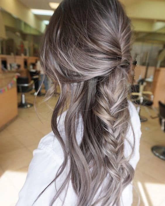 super long mousy brown hair with a large messy fishtail braid and waves down is a chic and lovely idea