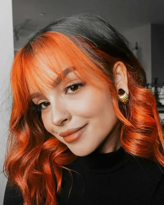 two-tone hair - black and bold orange around the face plus orange wispy fringe and waves is a unique idea that wows