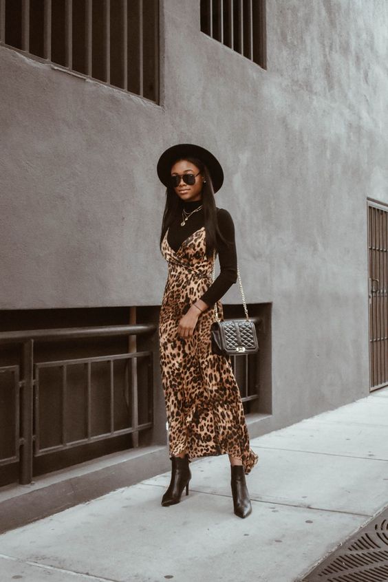 a black turtleneck, a leopard print slip dress, a black bag and ankle boots, a black hat for this fall