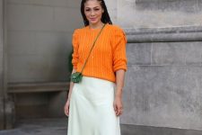 07 a classy fall look with an orange jumper, a neutral leather skirt, white trainers and a tiny green bag