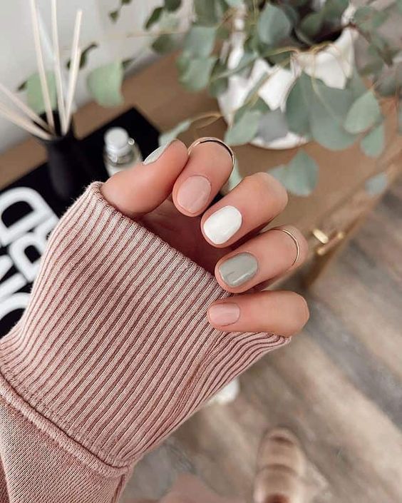 a delicate and neutral autumn manicure in light green, blush and white is a lovely idea of a mismatching manicure