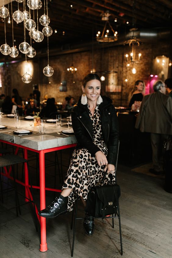 a leopard midi dress, a cropped black leather jacket, black buckle boots and a large black bag