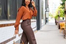 08 an elegant and bright fall work outfit with a burnt orange shirt, brown trousers, grey shoes and an orange bag