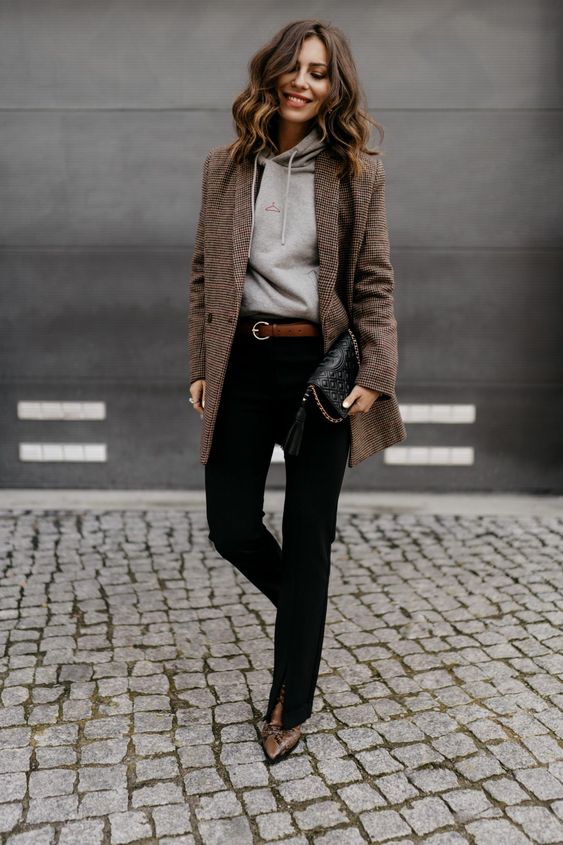 a chic fall work outfit with a grey hoodie, a brown printed blazer, black jeans, a brown belt and snakeskin boots plus a black bag