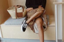 10 a black hoodie, a leopard print midi skirt, black sneakers and a woven bag are a cool combo for a cold day