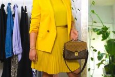 10 a bold fall work outfit with a yellow top, a matchign blazer and a matching pleated over the knee skirt, white sneakers and a printed bag