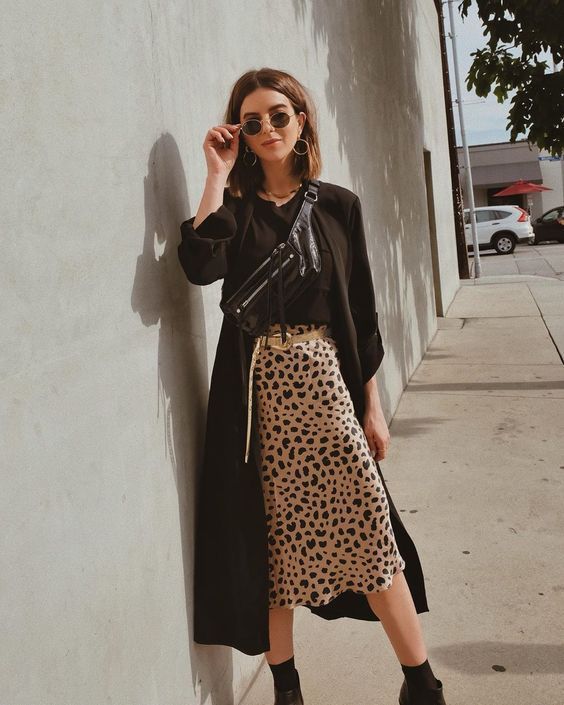 a black t-shirt, a leopard printed midi, black boots and socks, a black trench and a waistbag for this fall