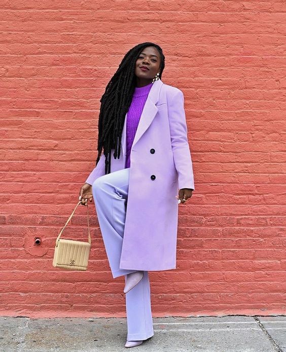 a classy pastel outfit with lilac pants and a trench, a purple sweater, pale lilac boots and a neutral bag