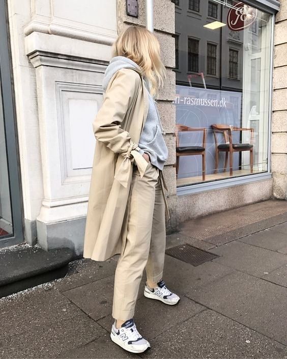 a neutral fall work look with a grey hoodie, tan pants, a tan trench and white trainers is super comfortable