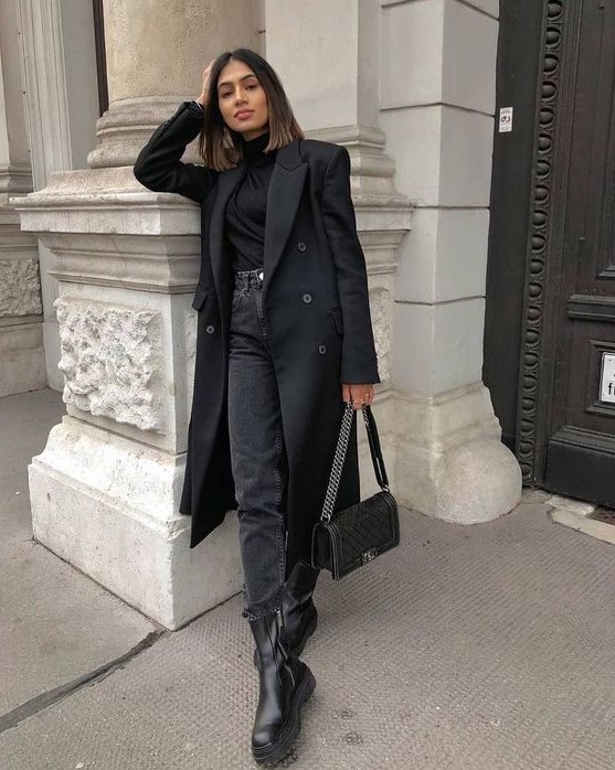 a monochromatic outfit with a black turtleneck, grey jeans, black combat boots, a black trench and a black bag