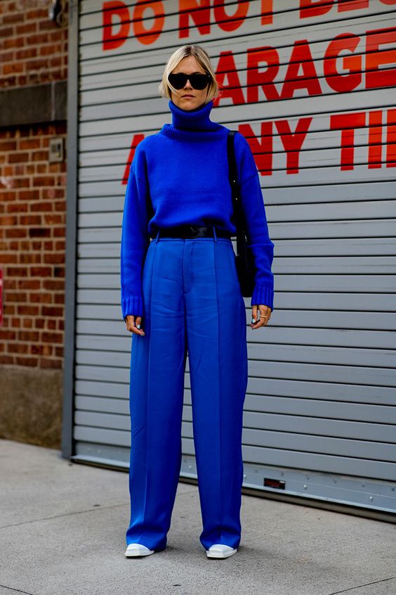 a simple bold blue outfit with wideleg high waisted pants, a sweater, white boots and a black bag