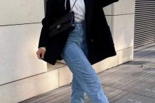 15 a stylish and contrasting fall work outfit with a white hoodie, blue high waisted jeans, black and white trainers, a black blazer and a black bag