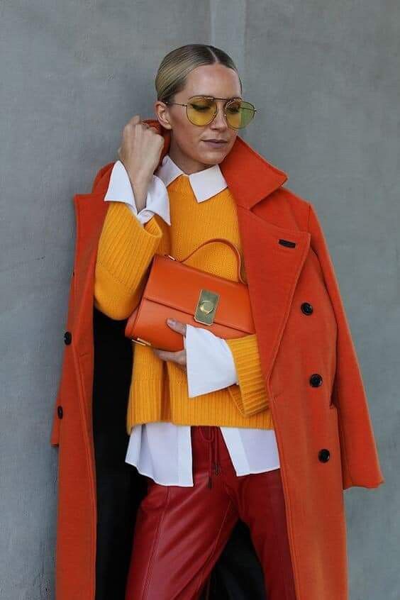 a bold fall work look with a white shirt, a yellow jumper, red leather pants, an orange coat and an orange bag