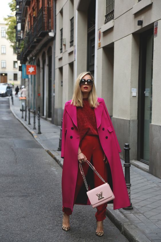 a bold fall work outfit with a red jumper and trousers, leopard print shoes, a hot pink trench and a light pink bag