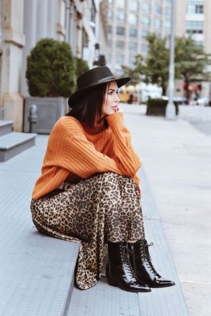 an orange ribbed sweater, a leopard slip midi skirt, black lacquer boots, a black hat for a lovely fall look