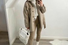 20 a fall to winter look with a white sweater, grey leggings, a grey shirt jacket, creamy Chelsea boots and a backpack